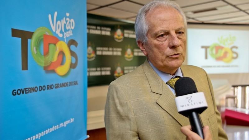 De pé, Cairoli fala ao jornalista que segura o microfone.