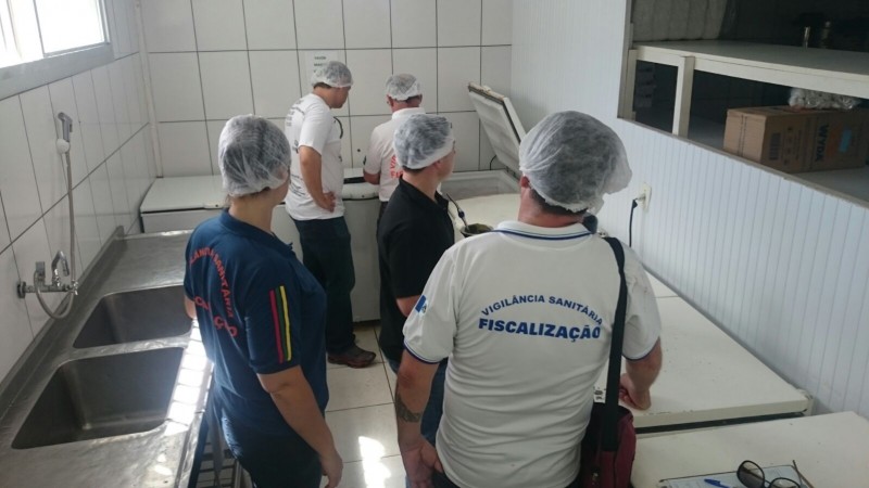Cinco pessoas olham os equipamentos.