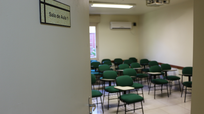 A imagem mostra uma sala vazia com as cadeiras.