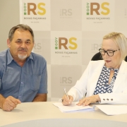 Secretária Arita assina documento sentada ao lado de Adelar.