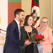 Secretária Arita, governador Leite e outra mulher segura um buquê de rosas.