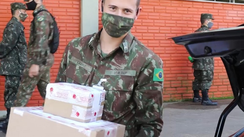 Um militar carrega algumas caixas grandes com medicamentos. 