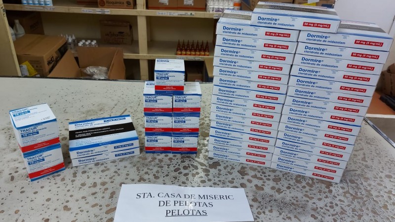 A imagem mostra várias caixas de vacinas em cima de uma mesa. 