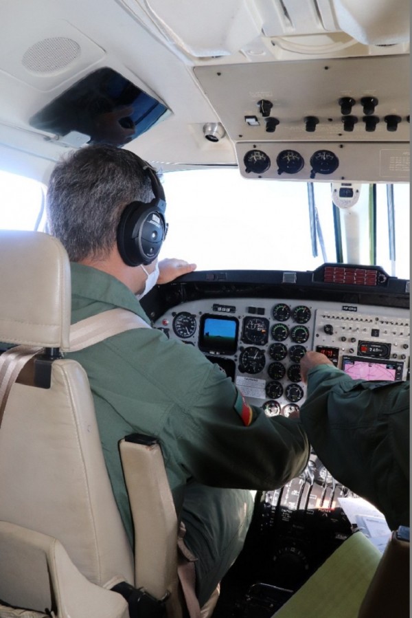 A imagem mostra o major pilotando a aeronave. 