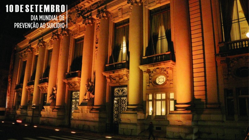 A imagem mostra o Palácio Piratini iluminado de amarelo, à noite. No lado esquerdo, no alto, tem a mensagem "10 de setembro: Dia Mundial de Prevenção ao Suicídio".