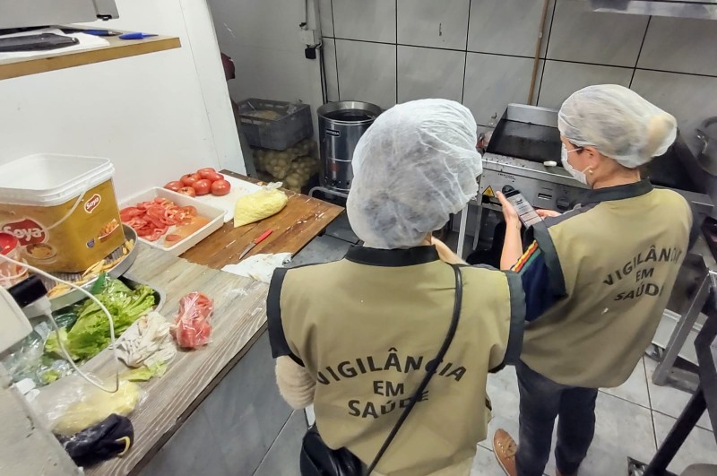 Duas profissionais da Vigilância em Saúde fazem vistoria na cozinha de um restaurante.