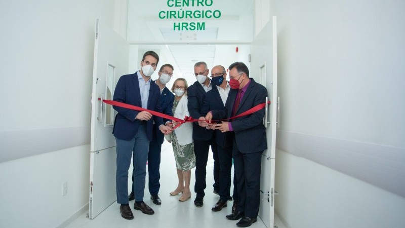 Na porta de entrada com uma placa em letras verdes escrito Centro Círúrgico, Governador Leite, secretária Arita e prefeito de Santa Maria , Jorge Pozzobom, entre mais três autoridades que cortaram a fita de cor vermelha