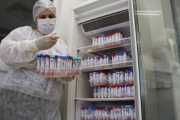 Uma profissional de saúde manuseia amostras de secreção do nariz e boca de pacientes com suspeita de covid-19. 