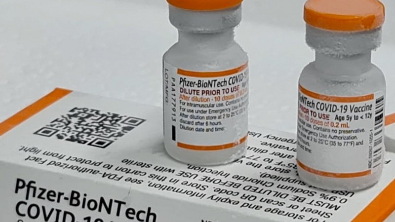 A imagem mostra duas doses da vacina Pfizer em cima de uma caixa da mesma vacina. 