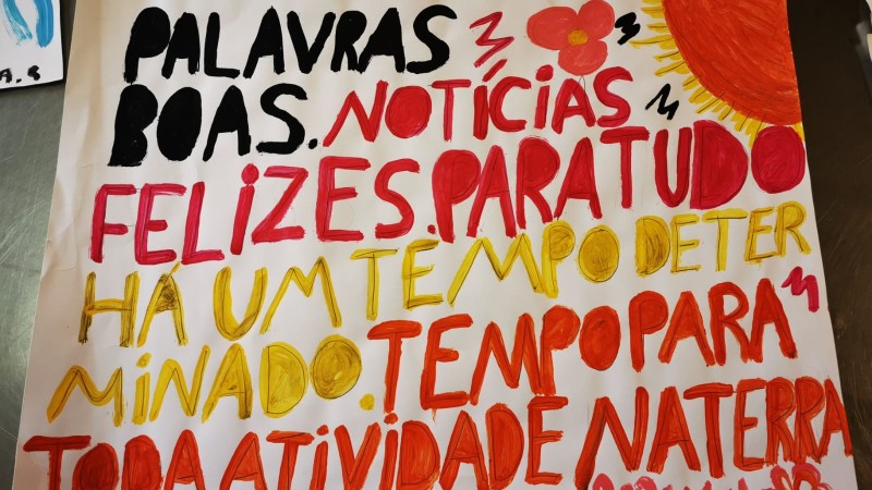 A  imagem mostra o trabalho de um interno com mensagens escritas com tinta e mais o desenho de um sol e de uma flor. 