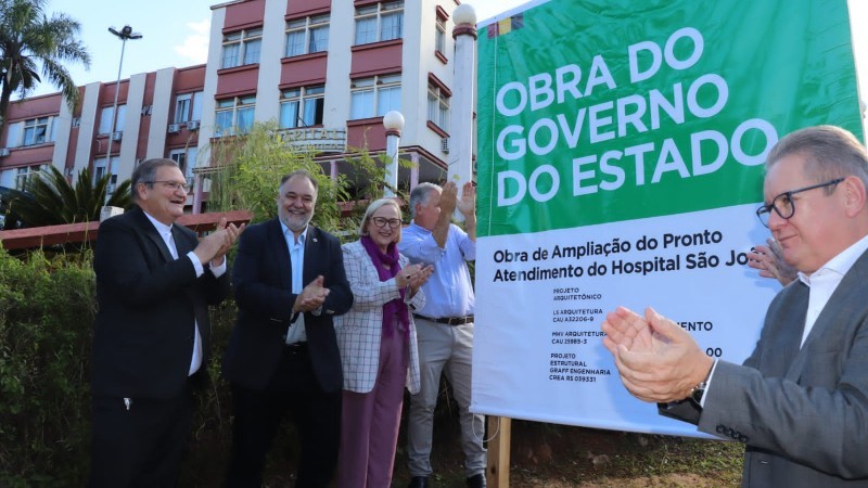 De pé, o Governador Ranolfo, a Secretária Arita e mais quatro pessoas aplaudem o descerramento da placa.