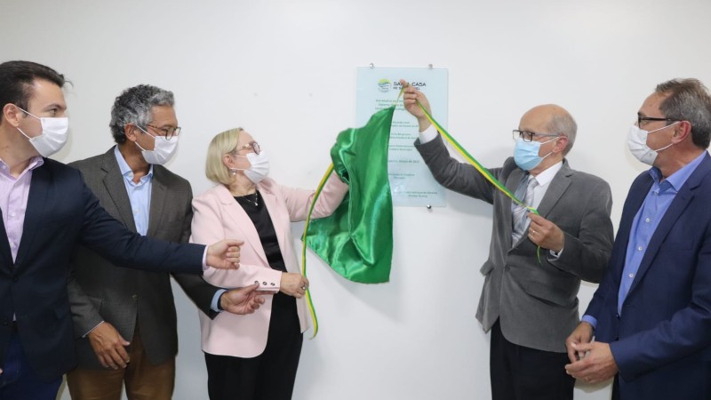 secretária da Saúde Arita Bergamann e mais quatro cidadãos retiram a cortina verde de descerramento da placa de inauguração