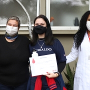 Mariana Ferreira Dias, no centro de duas mulheres, ao lado da equipe do Hemocentro.