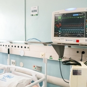 A imagem mostra um leito de UTI equipado. 