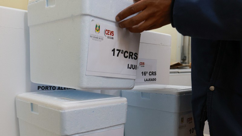 Uma mão coloca uma caixa de isopor em cima de outra. Outra caixa está ao lado.