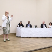 Arita Bergmann fala diante dos demais participantes da mesa de abertura