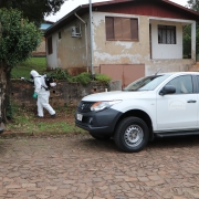 camionete da vigilância e agente trabalhando com o fumacê para combate ao mosquito Aedes Aegypti