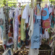 vestes falantes - jalecos pintados à mão pendurados em cabides.