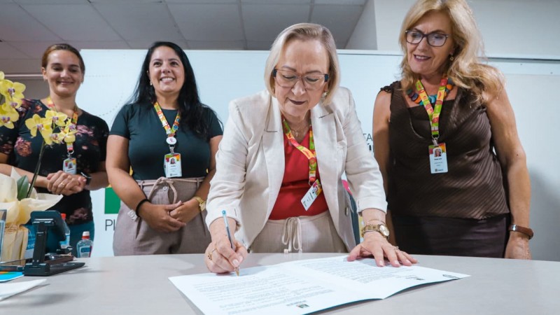 Em primeiro plano, Arita Bergmann assina uma das portarias que ampliaram os recursos em sa&uacute;de mental e sa&uacute;de bucal