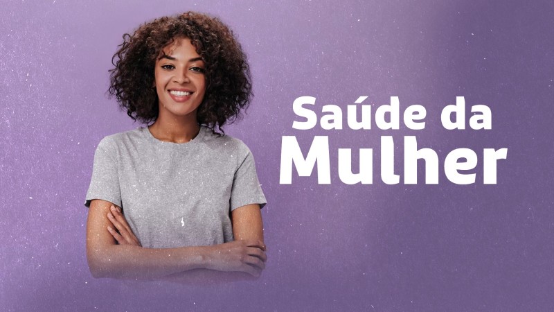 Imagem com fundo roxo em textura suave. No lado esquerdo, h&aacute; uma pessoa em posi&ccedil;&atilde;o frontal com os bra&ccedil;os cruzados, vestindo uma camiseta cinza. No lado direito, em texto branco grande, aparece a frase &ldquo;Sa&uacute;de da Mulher&rdquo;.