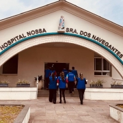 Fotografia da fachada principal do Hospital Nossa Senhora dos Navegantes. O pr&eacute;dio tem arquitetura sim&eacute;trica, com uma grande entrada em formato de arco revestida por tijolos claros. Na parte superior da fachada est&aacute; a inscri&ccedil;&atilde;o &ldquo;HOSPITAL NOSSA SRA. DOS NAVEGANTES&rdquo; e, ao centro, acima do arco, h&aacute; uma imagem religiosa instalada em um nicho.

Em primeiro plano, um caminho pavimentado conduz &agrave; entrada do hospital. Ao longo do percurso, h&aacute; canteiros com vegeta&ccedil;&atilde;o baixa e vasos distribu&iacute;dos junto &agrave; fachada. Um grupo de pessoas vestindo coletes azuis caminha em dire&ccedil;&atilde;o &agrave; porta principal do edif&iacute;cio. Nas laterais da constru&ccedil;&atilde;o s&atilde;o vis&iacute;veis janelas e, ao fundo, parte de edifica&ccedil;&otilde;es mais altas e &aacute;rvores. A imagem foi registrada durante o dia, sob ilumina&ccedil;&atilde;o natural e c&eacute;u parcialmente nublado.