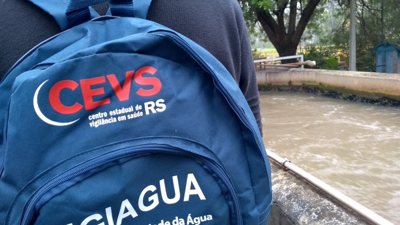 Detalhe de uma mochila do CEVS nas costas de uma pessoa.