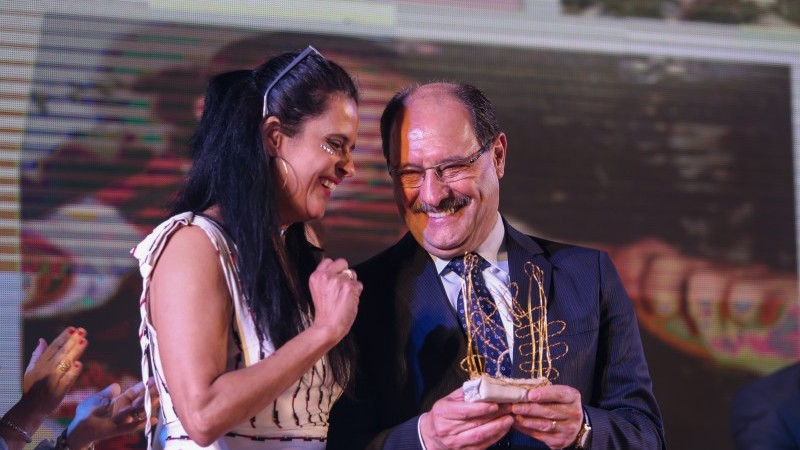 O governador do estado, José Ivo Sartori recebe troféu em homenagem  pela sua contribuição para fortalecimento do Programa Primeira Infância melhor das mãos da coordenadora adjunta do programa Gisele Mariuse da Silva 