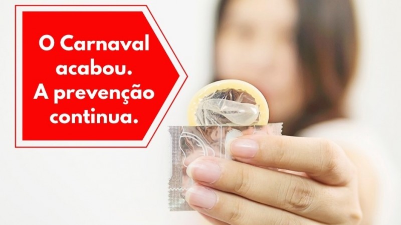 Uma mulher mostra um preservativo. No alto, à esquerda, tem a mensagem: o Carnaval acabou. A prevenção continua.