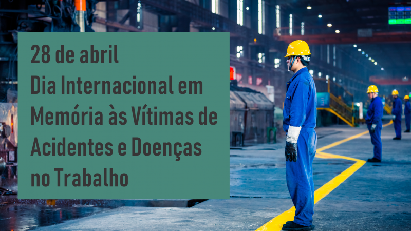 Texto informando que 28 de abril é Dia Internacional em Memória às Vítimas de Acidentes e Doenças no Trabalho sobre foto com trabalhadores em pé, de macacão azul, luvas e capacetes amarelos