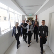 Secretária Arita e outras pessoas caminham pelos corredores do hospital. 