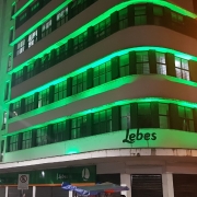  Lojas Lebes (Edifício Guaspariem Porto Alegre) iluminada de verde à noite.