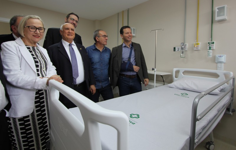 A Secretária Arita e alguns homens visitam o quarto de hospital.